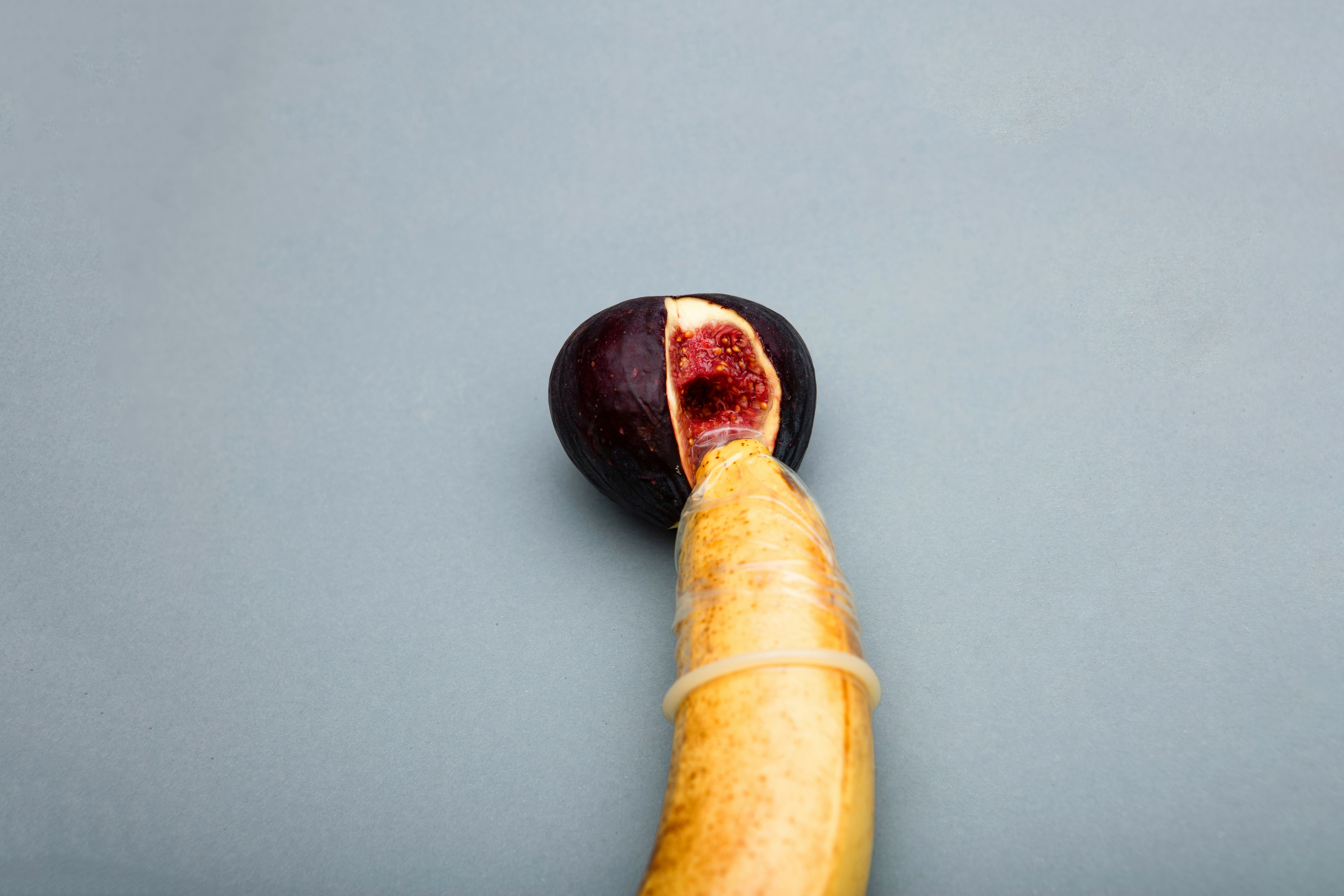 open fig with a hole from a banana with condom