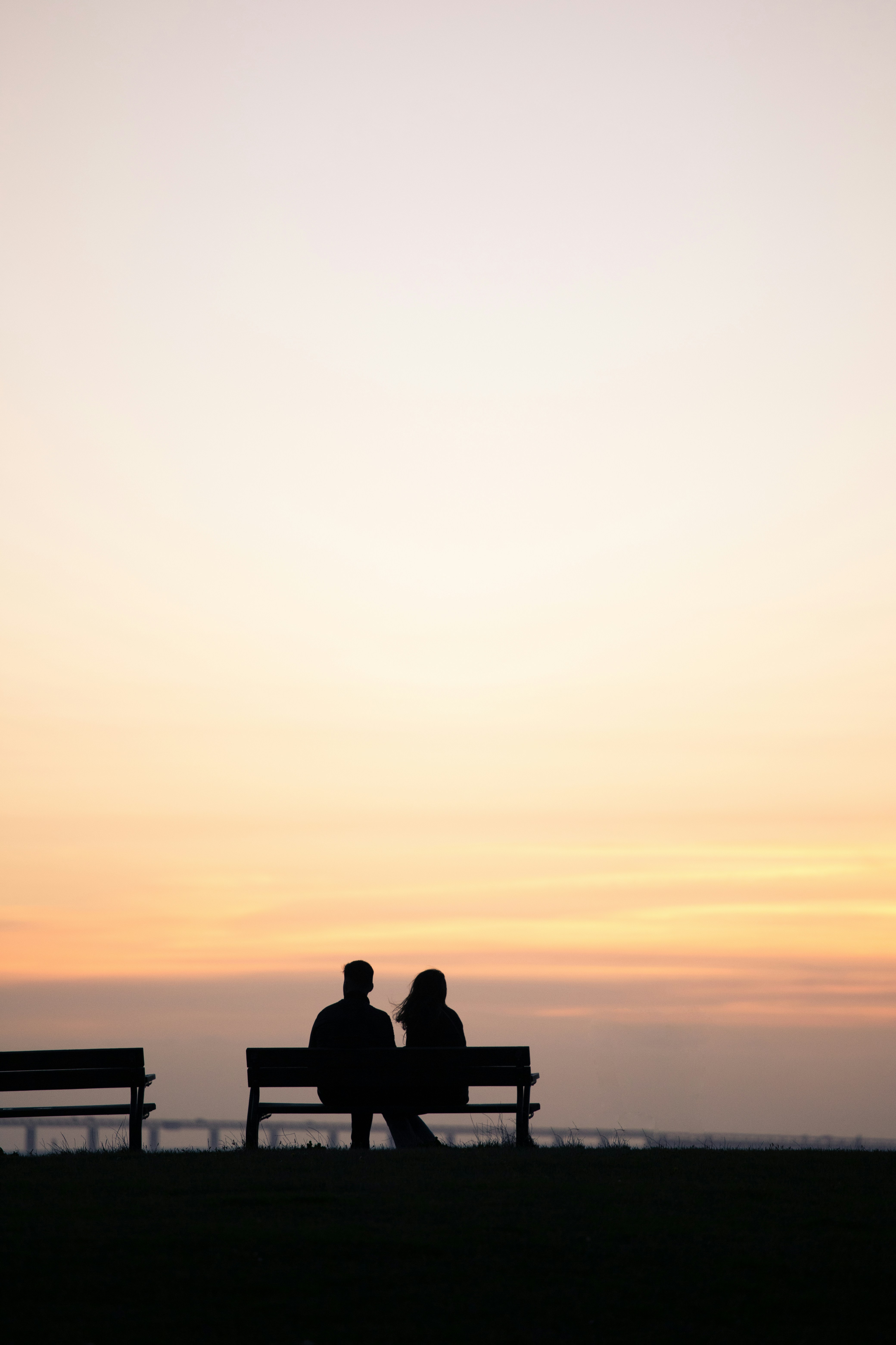 couple on date looking the sunshine while sitting on bench