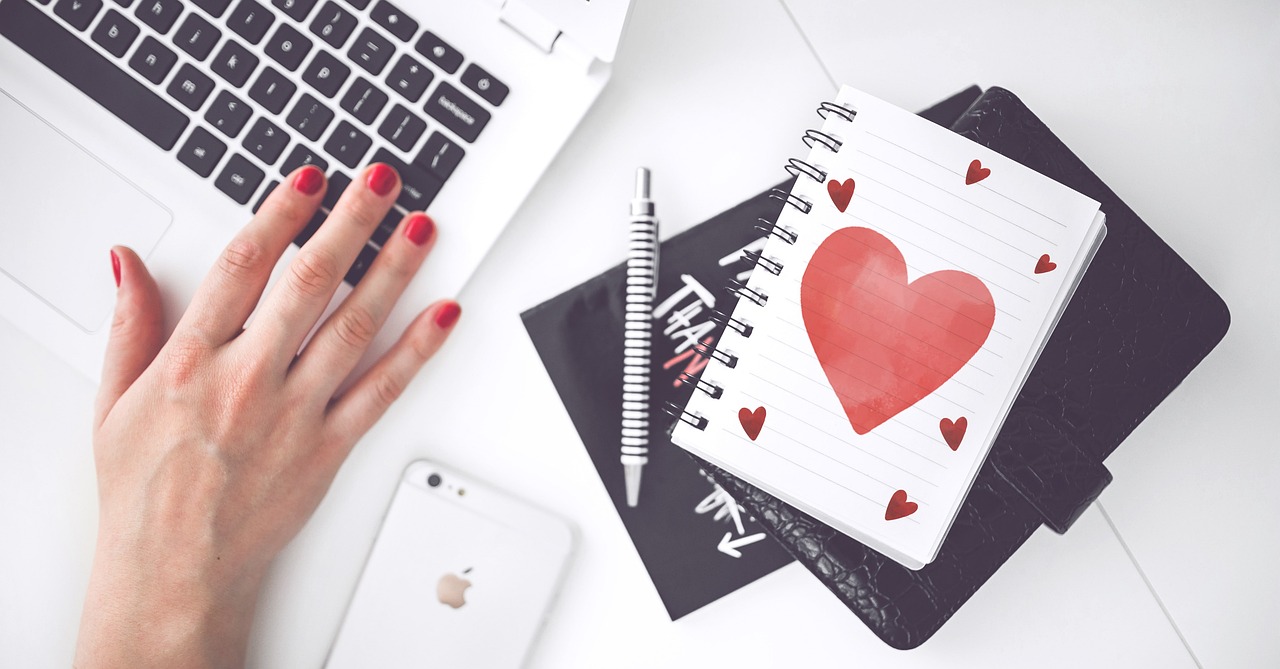hand on keyboard with drawn heart by side