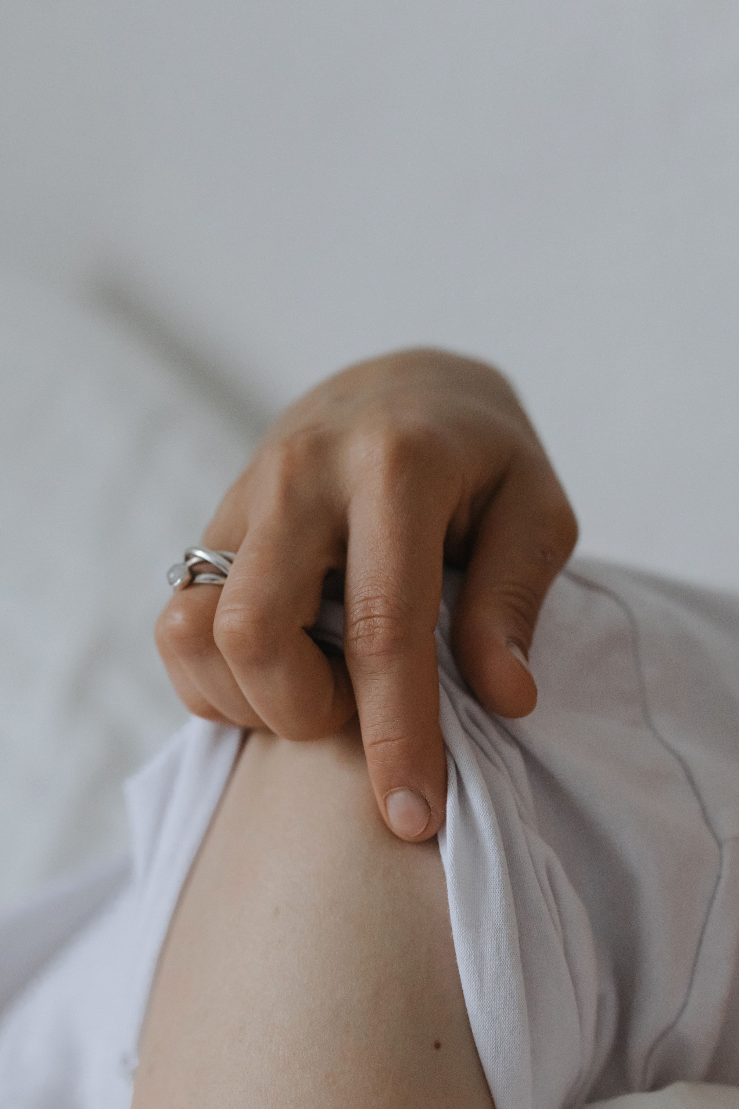 fingers trying to take off partner's white clothes