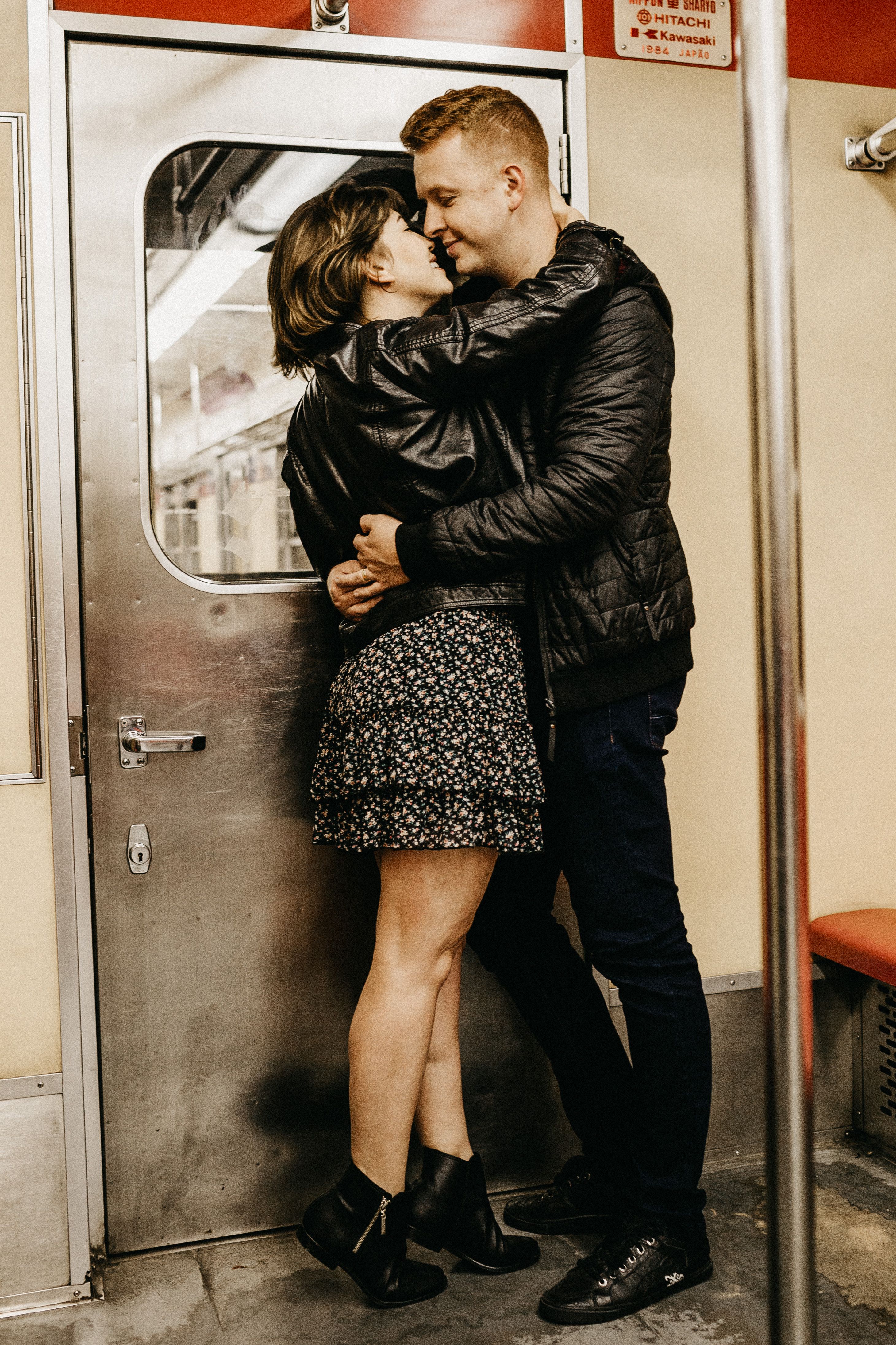 straight couple is kissing in subway